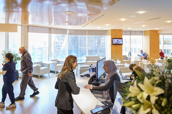 Woman checking with the Information desk in the waiting room at Cleveland Clinic Canada.