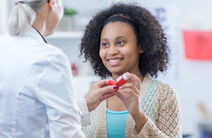 Doctor helping a patient to use a breathing inhaler.